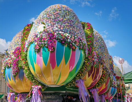 A festive Easter parade float adorned with flowers, ribbons, and oversized Easter eggs.