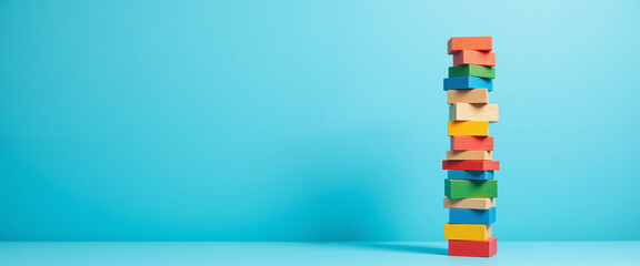 Colorful building blocks stacked high against a bright blue background, conveying a sense of stability and teamwork, representing the foundation of Effective Leadership