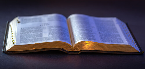 Obraz premium Open Holy Bible on the table. Religion concept. Bible on black background.