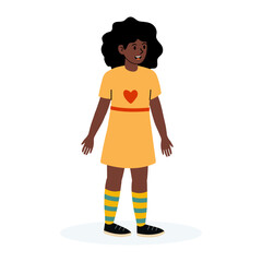 Young girl with curly hair in yellow dress and colorful socks standing happily