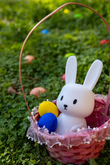 Cute white bunny figure with colorful eggs in a basket during Easter festivities