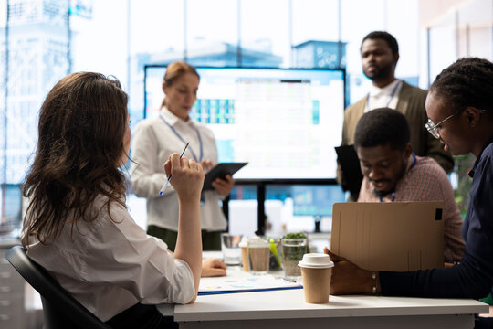 Business partners presenting annual sales reports in a meeting with investors, showing internal communication strategies on an interactive board to ensure performance. Management team.