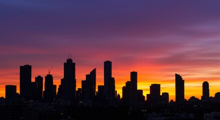 Urban Silhouette at Dawn: A breathtaking cityscape emerges from the twilight, with towering silhouettes of buildings set against the vibrant hues of a dawn sky.