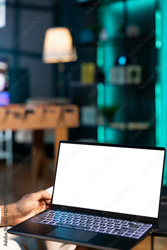 Poster remote employee at home on couch inputting data on isolated screen laptop. man in apartment trying t
