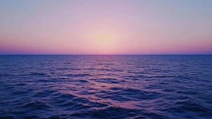 Fototapeta premium Cape Greco's coastline at dusk, with the horizon painted in pink and orange while the sea sparkles under the fading sunlight.
