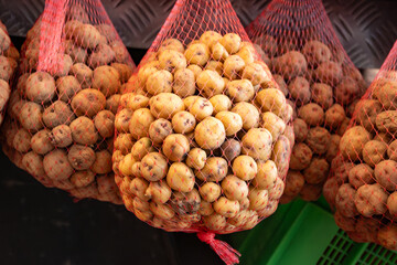 Special small tasty potatoes papas negras on market hanging in nets, main dish on Canary islands, Spain, cooked with salt and served with mojo sauces