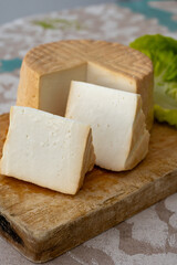 Cheese collection, piece of round fresh smoked Spanish goat cheese close up