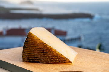 Spanish hard cheese, curado, manchego, goat cheese served outdoor with blue sea on background,...