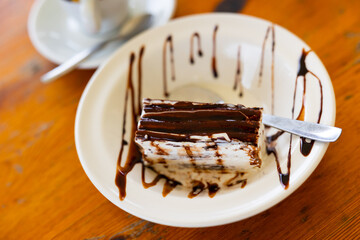 Appetizing ice cream with chocolate crust served on saucer for dessert