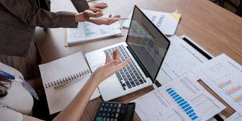Team members reviewing financial reports and using technology for effective business strategy planning.