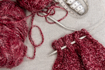 Fototapeta premium yarns, knitting needles and pattern sample on grey background.