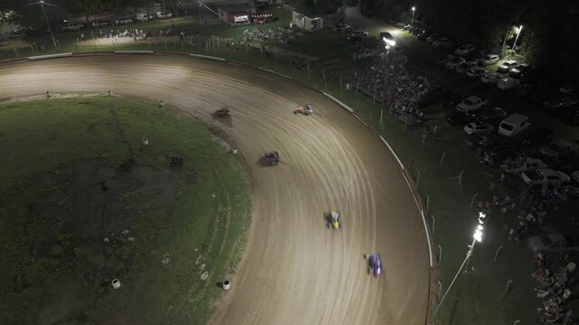 Toma a&eacute;rea de una carrera de midgets en circuito de tierra. Autos derrapando a gran velocidad, capturando la adrenalina y emoci&oacute;n del automovilismo desde una vista &uacute;nica con drone