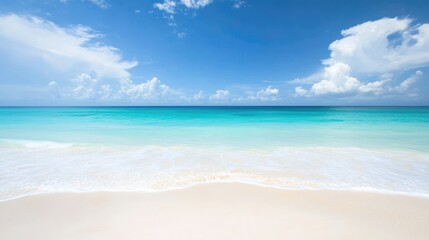 Fototapeta premium A serene beach scene with the open sea in the background, soft white sand and a clear horizon.