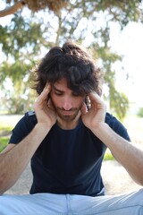 Pensive Long Hair Man Sitting On The Sidewalk Reflecting On Debts
