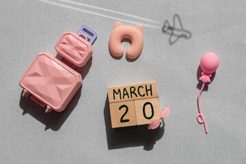 Wooden block calendar with date March 20 in the hand of puppet