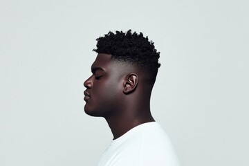 Obraz premium Profile shot of a young Black man with a stylish haircut, wearing a white t shirt, exuding confidence and calmness, perfect for lifestyle and beauty concepts