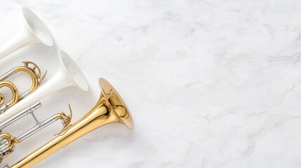 Obraz premium Gold, silver, and white trumpets arranged on a polished white marble surface in bright studio light.