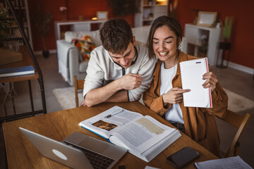 Fototapeta premium young student show notebook while have video call meeting on laptop