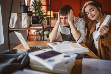 two tired and exhausted students show notes have video call on laptop