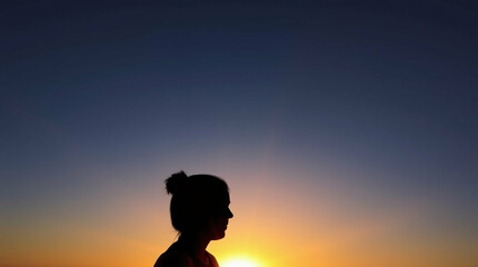 Fototapeta premium Silhouetted figure against a vibrant sunset's gradient and beams of light