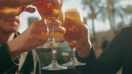 Young men having fun together,celebrating and cheers drinking beer and clinking glasses outdoorclose-up.