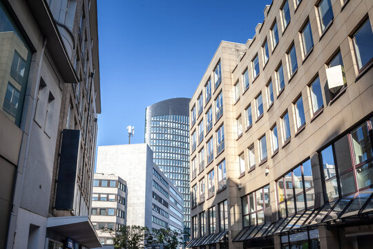 A bustling German business district featuring modern architecture and diverse office buildings. The tall structures line the urban street, reflecting the commercial growth and economic vitality of the - Powered by Adobe