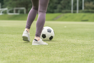 サッカー場でユニフォームを着てサッカー・フットサルの練習をする日本人女性