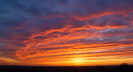 Fiery orange and pink clouds at sunset stretching across the sky.