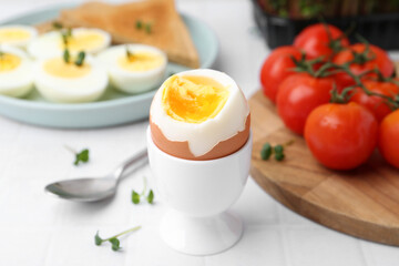 Soft boiled egg on white tiled table, closeup