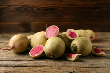 Whole and cut fresh turnips on wooden table