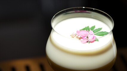 Closeup rotating in passion fruit smoothy cocktail glass serving special refreshing drink garnished...