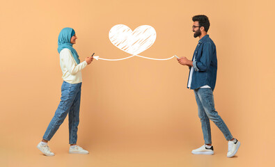 A couple stands together, each holding a smartphone while smiling. They are connected by a heart...