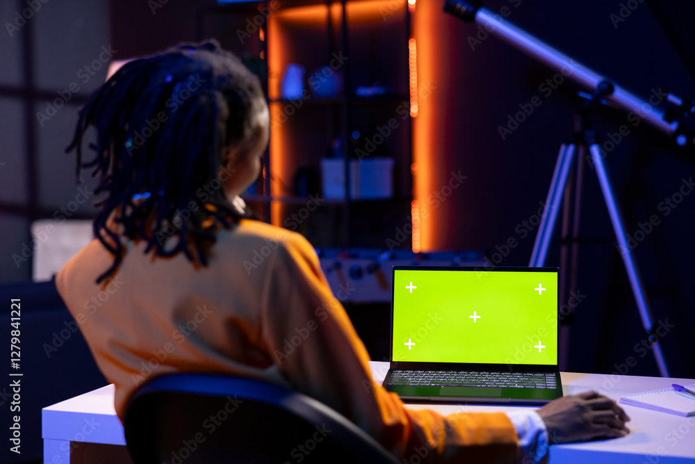 Poster freelancer in living room office using chroma key laptop to answer emails from business associates. 
