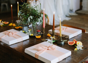 Elegant table setting with gifts and floral decor for a special celebration in a warm, inviting venue