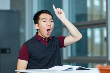 A young teenage boy student is performing vocal exercises in a room. He is doing singing practice to develop his voice and prepare for participating in the school choir.