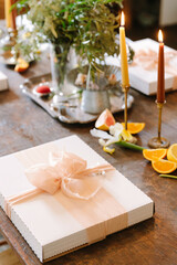 Elegant table setting with gifts, candles, and fresh fruits for a special celebration in a cozy indoor space