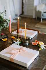Beautifully arranged gift boxes and candles create a cozy atmosphere for a celebration in a rustic setting