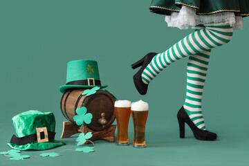 Woman in waitress costume with glasses of beer, leprechaun's hats, barrel and clovers on green...