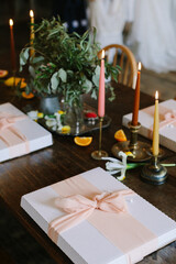 Elegant dinner setting with gift boxes and candlelight at a stylish table