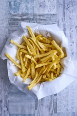Bowl with absorbent paper filled with crispy homemade french fries