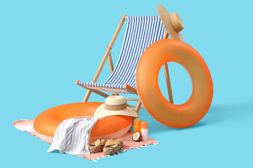 Inflatable ring, deck chair and beach accessories on blue background. Travel concept