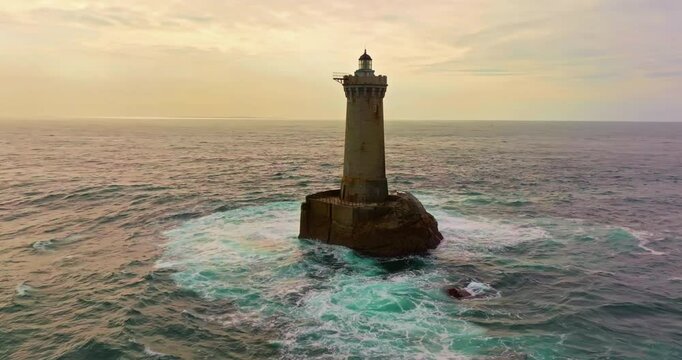 A rotating overhead shot of Phare du Four a lighthouse in Bretagne France. An ancient one standing far from the shore in the ocean and the first to meet huge waves