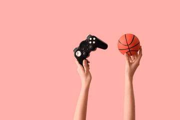 Woman holding game pad with ball on pink background © Pixel-Shot