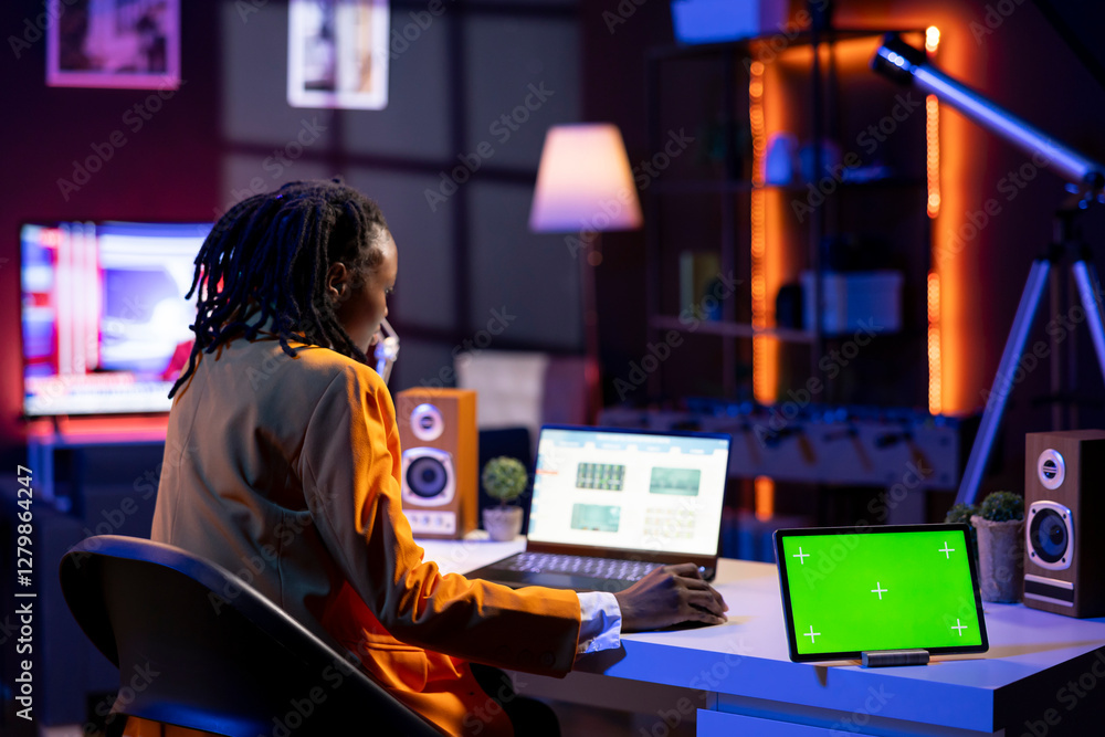 Poster mockup tablet next to teleworker analyzing data on laptop at desk, compiling reports. isolated scree
