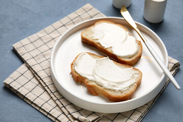 Plate of tasty bruschetta with processed cheese on napkin on blue background. Closeup