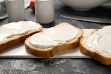 Board of tasty bruschetta with processed cheese on black background. Closeup