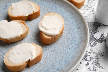Plate of tasty bruschetta with processed cheese on grunge background, closeup