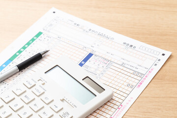 机に置かれた確定申告書類と電卓