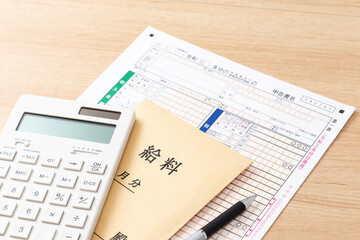 机に置かれた確定申告書類と電卓