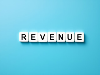 "Revenue" Spelled Out with White Tiles on Light Blue Background